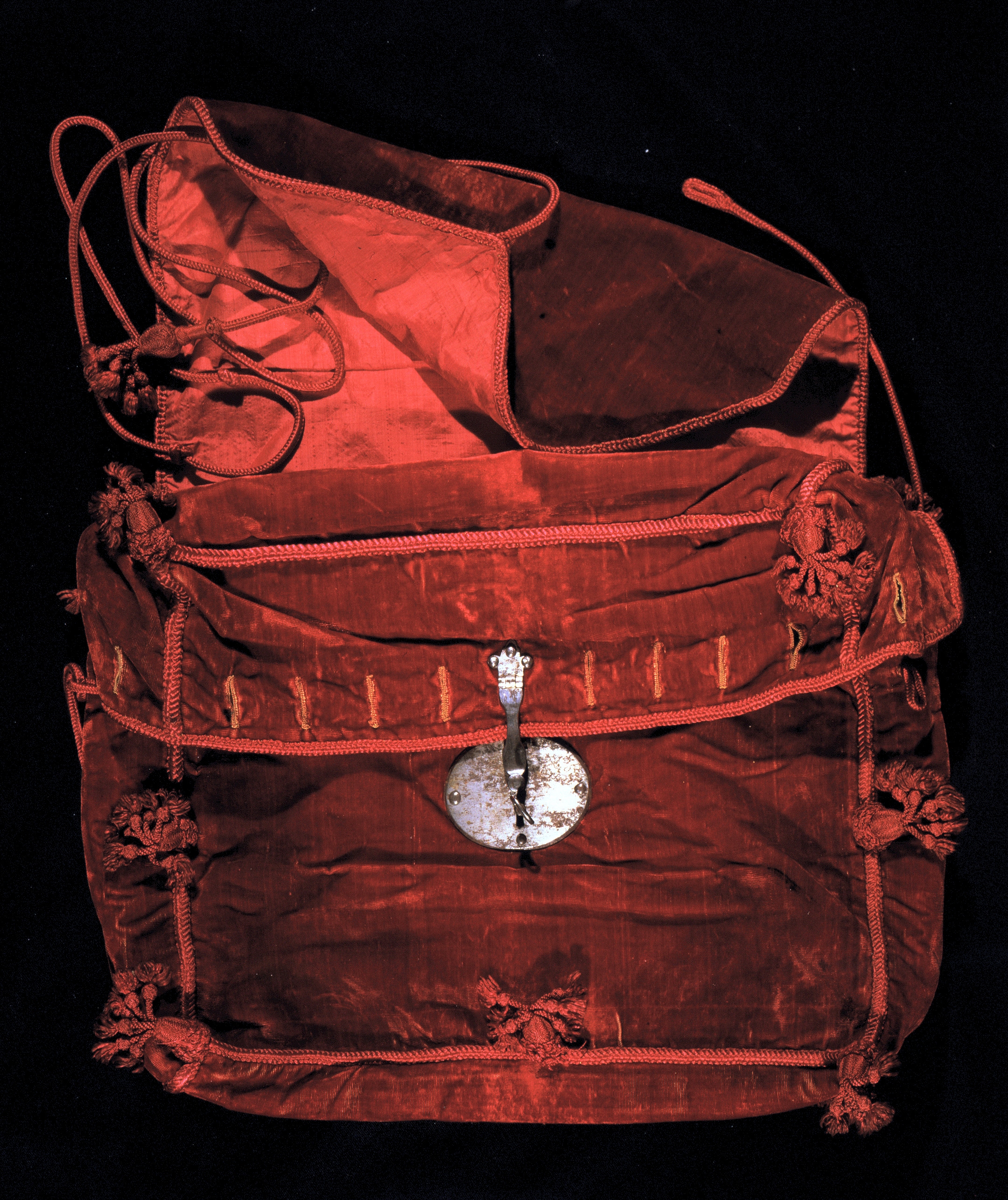 Cartera de terciopelo rojo con cordones de seda roja y borlas que penden de las esquinas, con cerradura de metal plateado, probablemente utilizada para transportar la Constitución de Cádiz de 1812 (390 x 330 x 95 mm.)